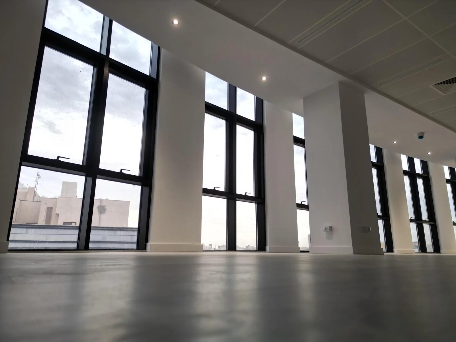 Interior daylight reflection highlighting rhythmic aluminium joinery modules